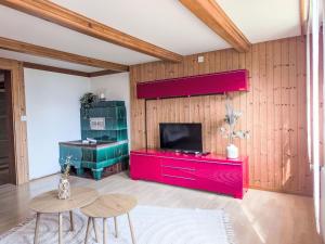 Una sala de estar con un centro de entretenimiento rojo y un televisor. en Apartment Galliweidli by Interhome, en Wengen