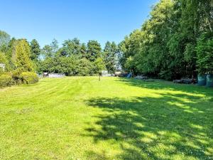 a large grass field with a tree shadow on it at Apartment Krüger-2 by Interhome in Großheide