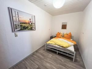 a bed in a room with a picture on the wall at Apartment Krüger-2 by Interhome in Großheide