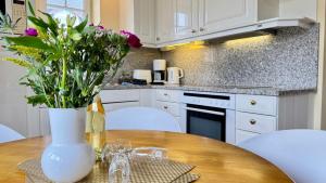 a kitchen with a table with a vase of flowers at Syltrose Whg 1a in Westerland (Sylt)
