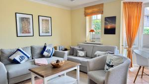 a living room with two couches and a table at Syltrose Whg 1a in Westerland (Sylt)