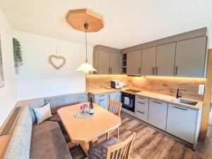 a kitchen and living room with a table and a couch at Apartment Dinkl by Interhome in Stummerberg