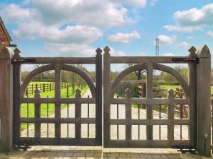 a wooden gate with arches in front of a field at Brankley Cottage - E4712 in Dunstall