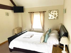 a bedroom with a large white bed with a window at Brankley Cottage - E4712 in Dunstall
