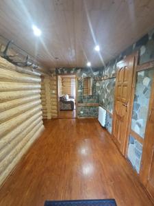 a large room with a wooden floor and a bedroom at Лісовик in Synevyrsʼka Polyana +28 photos