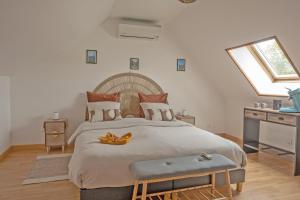 a bedroom with a large bed with two bananas on it at Gîte Marotte - Climatisé avec Jardin in Beaumont-en-Beine