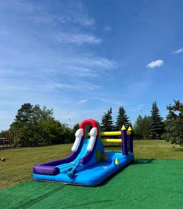 a playground with a water slide in a park at Holiday - domek letniskowy 2 in Charzykowy