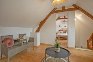 a living room with a table and chairs and a bed at Gîte Marotte - Climatisé avec Jardin in Beaumont-en-Beine