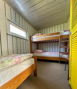 a room with two bunk beds and a window at Holiday - domek letniskowy 2 in Charzykowy