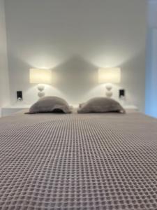a bedroom with a bed with two lamps on it at Estrella house in Kithnos