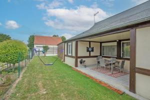 a house with a yard with a swing at Gîte Marotte - Climatisé avec Jardin in Beaumont-en-Beine