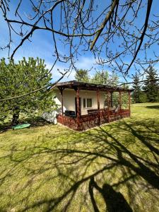 a house with a gazebo in a yard at Holiday - domek letniskowy 2 in Charzykowy
