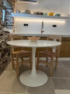 a white table with chairs and a sink in a kitchen at Estrella house in Kithnos +25 photos