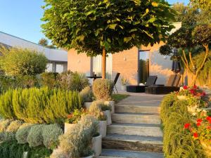 a garden with stairs and flowers in front of a building at Villa Hana With Pool in Shetaj