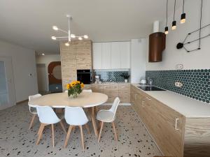 a kitchen with a table and chairs and a kitchen with blue tiles at Sweet Home Apartament in Przechlewo