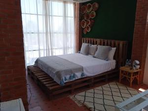 a bedroom with a large bed in a brick room at Tree Valley Bungalow in Tétouan