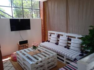 a living room with two benches with pillows and a tv at Tree Valley Bungalow in Tétouan