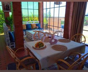 a table with chairs and a bowl of fruit on it at Tree Valley Bungalow in Tétouan
