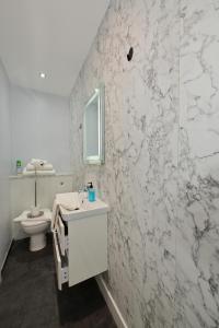 Un baño blanco con lavabo e inodoro. en Lyme Bay House, en Dawlish 37 fotos más