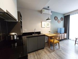 a kitchen with a sink and a table and a kitchen with a dining room at The Deck Patong in Patong Beach