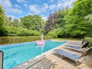 a swimming pool with a pink swan in the middle at Holiday Home Villa Honfleur by Interhome in Gonneville-sur-Honfleur
