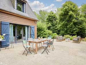 a wooden table and chairs on a patio at Holiday Home Villa Honfleur by Interhome in Gonneville-sur-Honfleur +26 photos