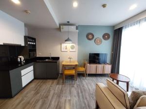 a kitchen and living room with a couch and a table at The Deck Patong in Patong Beach