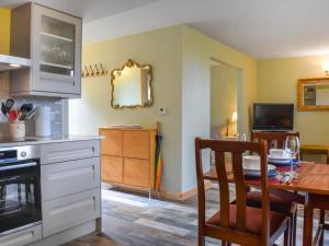 a kitchen with a table and a dining room at The Coach House Annexe in Tilston