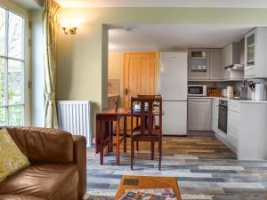 a living room with a table and a kitchen at The Coach House Annexe in Tilston