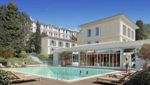 a swimming pool in front of a large building at Hôtel Miléade L'Orangeraie - Menton in Menton