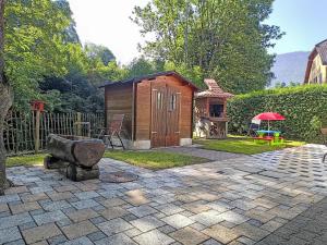 a small wooden shed with a grill in a yard at Holiday Home Maison des Gorges by Interhome in Moutier