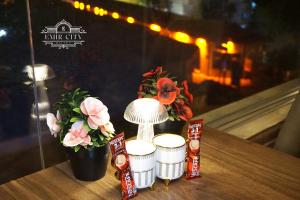 伯萨Emir City Hotel的桌子上放着三杯,花朵