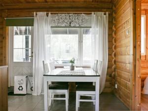 une table blanche et des chaises dans une pièce avec une fenêtre dans l'établissement Holiday Home Siili by Interhome, à Savonranta