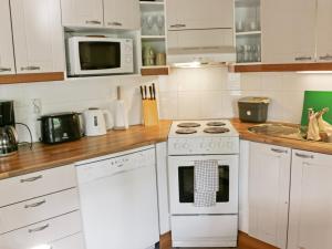 La cuisine est équipée de placards blancs et d'un four avec plaques de cuisson blanches. dans l'établissement Holiday Home Siili by Interhome, à Savonranta 10 autres photos