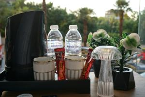 a tray with bottles of water and cups on a table at Emir City Hotel in Bursa