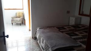 1 dormitorio con 1 cama, 1 silla y 1 ventana en Casa de La Luna, en Monte Verde