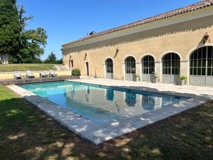 a swimming pool in a yard next to a building at Château d'Arcamont in Roquelaure