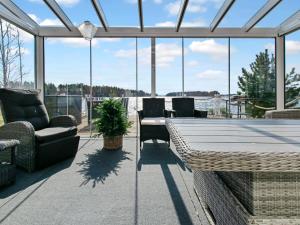 a conservatory with a table and chairs and windows at Holiday Home Kesäranta by Interhome in Alavus +20 photos