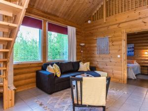 - un salon avec un canapé bleu dans une cabane en rondins dans l'établissement Holiday Home Ilves by Interhome, à Savonranta