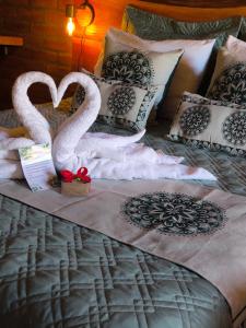 two swans made out of towels on a bed at Pousada das Castanheiras in Monte Verde