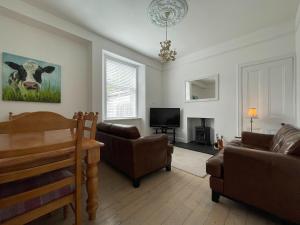 a living room with a cow painting on the wall at Stanford House in Inverness