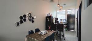 a dining room with a table and chairs and a kitchen at Tuaran 88 Homestay in Tuaran