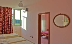 a bedroom with a mirror and a bed and a window at Gurguri Hotel in Golem