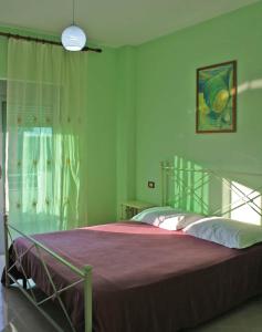 a bedroom with a large bed with a purple blanket at Gurguri Hotel in Golem
