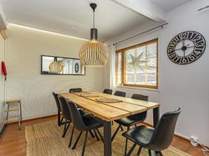 ein Esszimmer mit Tisch und Stühlen und einer Uhr in der Unterkunft Holiday Home Levin alppi 3 b 7 by Interhome in Levi