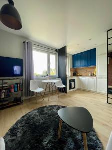 a living room with a table and chairs and a kitchen at Stylish apartment by the castle in Malbork