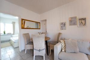 ein Wohnzimmer mit einer Couch und einem Tisch und Stühlen in der Unterkunft Reiterhof an der Nordsee in Witzwort