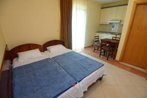 a bedroom with a bed and a kitchen with a table at Blue Palace Guest House in Budva