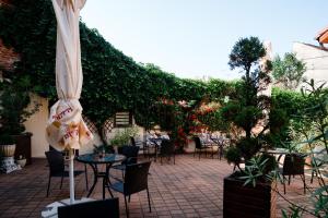 a patio with tables and chairs and an umbrella at Rosen Villa Sibiu in Sibiu