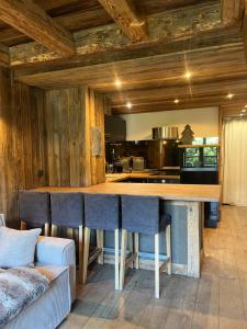 a kitchen with a large bar with blue chairs at Appartement du Petit Bois in Megève